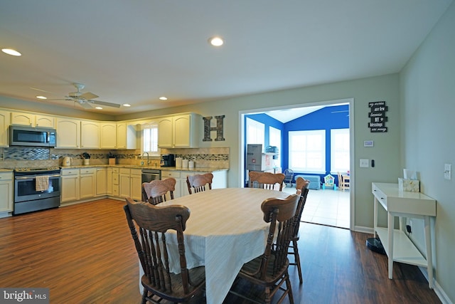 dining area with plenty of natural light, dark hardwood / wood-style floors, lofted ceiling, and ceiling fan