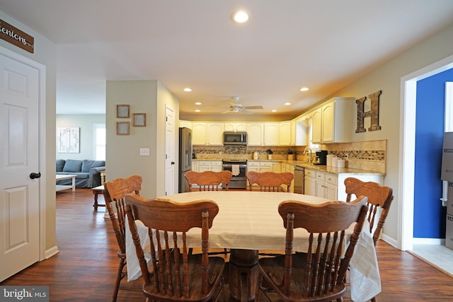 dining room with sink, dark hardwood / wood-style floors, and ceiling fan