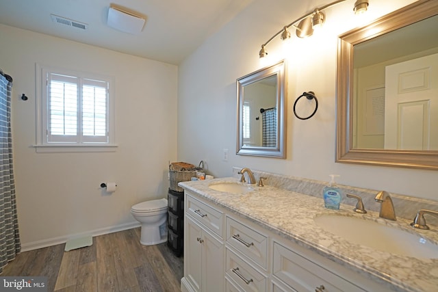 bathroom featuring wood-type flooring, vanity, and toilet