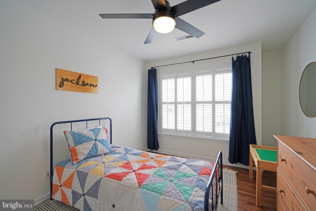 bedroom with ceiling fan, dark hardwood / wood-style floors, and multiple windows