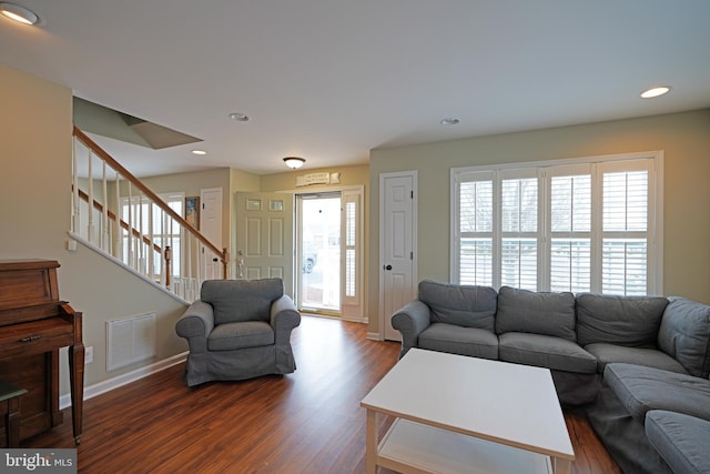 living room featuring dark wood-type flooring and a wealth of natural light