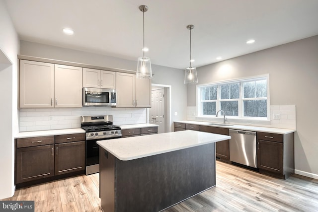 kitchen featuring pendant lighting, a center island, sink, tasteful backsplash, and stainless steel appliances