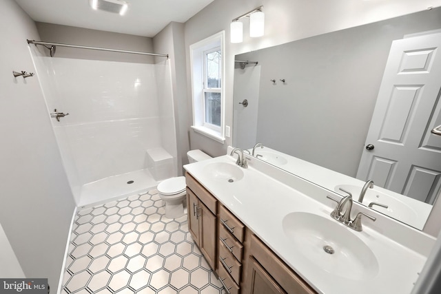 bathroom featuring vanity, toilet, and walk in shower