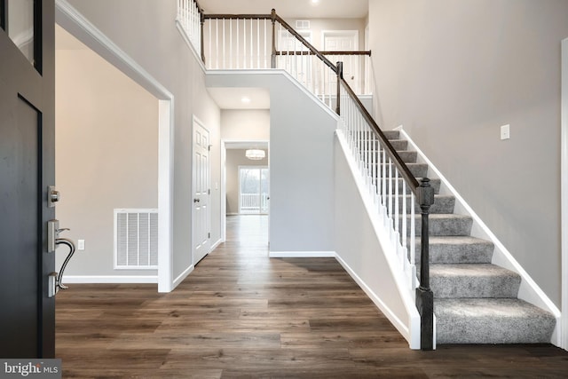 entryway featuring dark hardwood / wood-style floors and a high ceiling