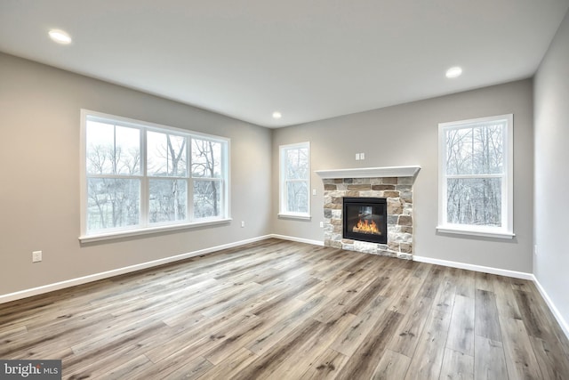 unfurnished living room featuring light wood-type flooring and a fireplace