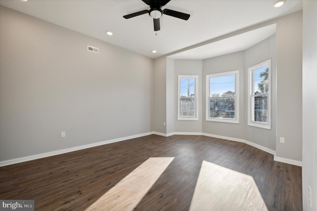 empty room with ceiling fan and dark wood-type flooring