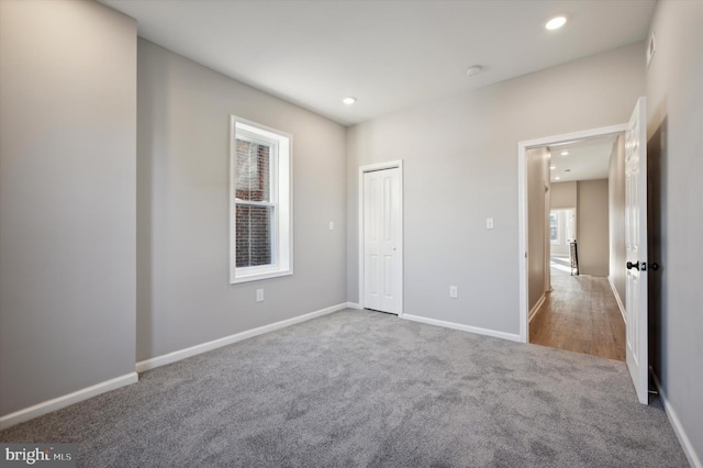 unfurnished bedroom featuring light carpet and a closet