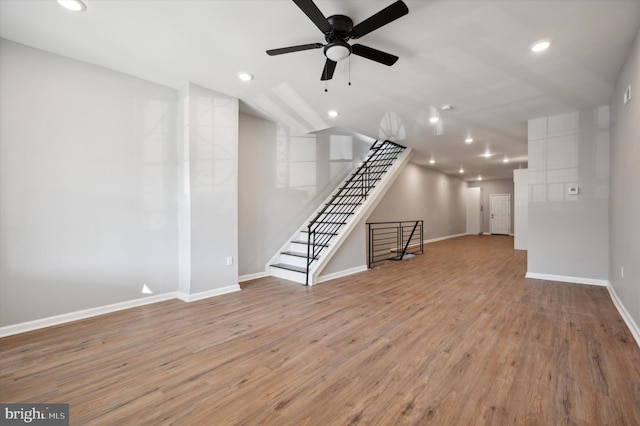 unfurnished living room with ceiling fan, light wood-type flooring, and vaulted ceiling