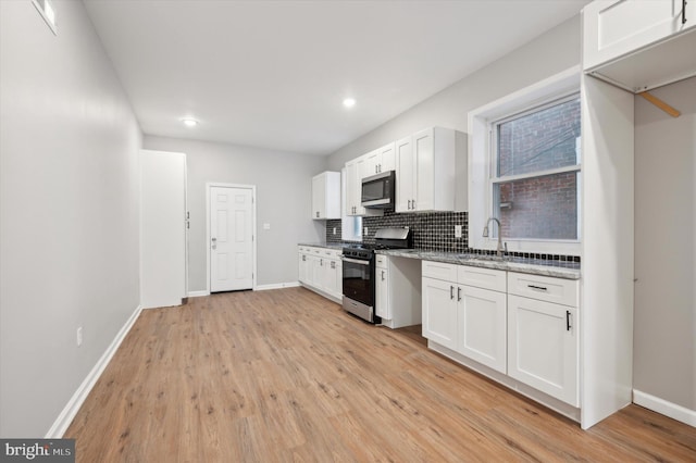 kitchen featuring white cabinets, light stone countertops, sink, and appliances with stainless steel finishes