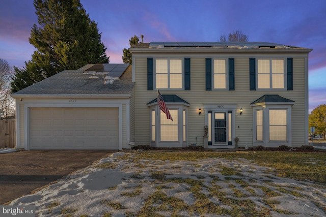 view of front of property with a garage and solar panels