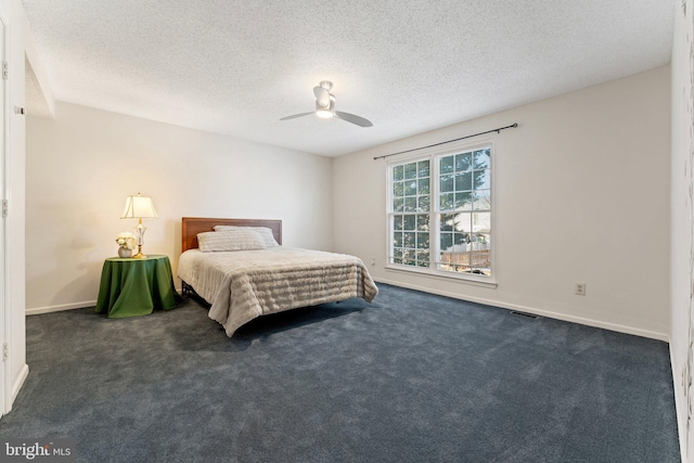 carpeted bedroom featuring ceiling fan and a textured ceiling