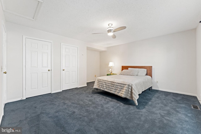 bedroom with dark carpet, a textured ceiling, and ceiling fan