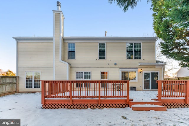 snow covered rear of property featuring a wooden deck and cooling unit