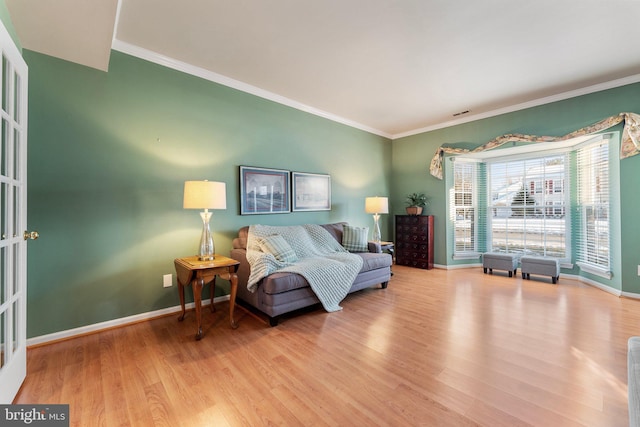 living area with ornamental molding and light wood-type flooring