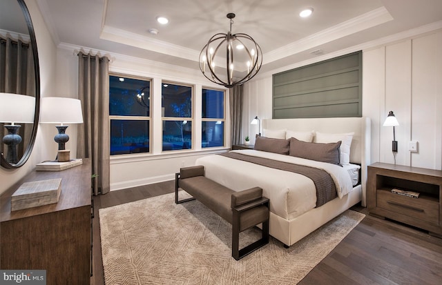 bedroom featuring a chandelier, ornamental molding, a raised ceiling, and dark wood-type flooring