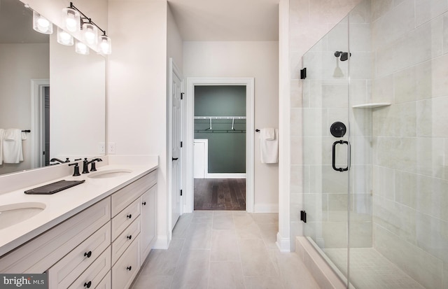 bathroom with tile patterned flooring, vanity, and a shower with door