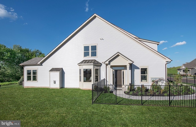 rear view of property with a lawn