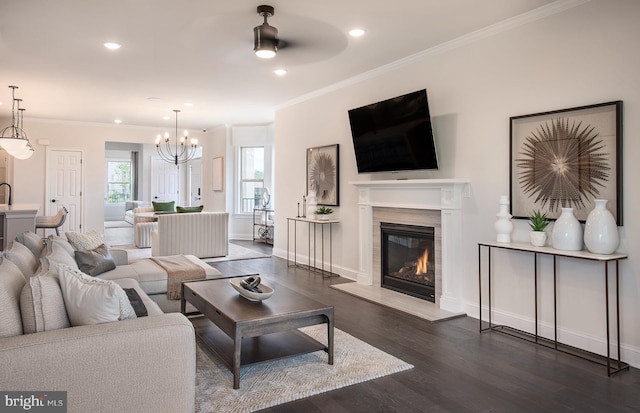 living room with ceiling fan with notable chandelier, dark hardwood / wood-style flooring, and ornamental molding