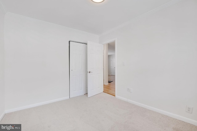 unfurnished bedroom featuring light colored carpet and crown molding