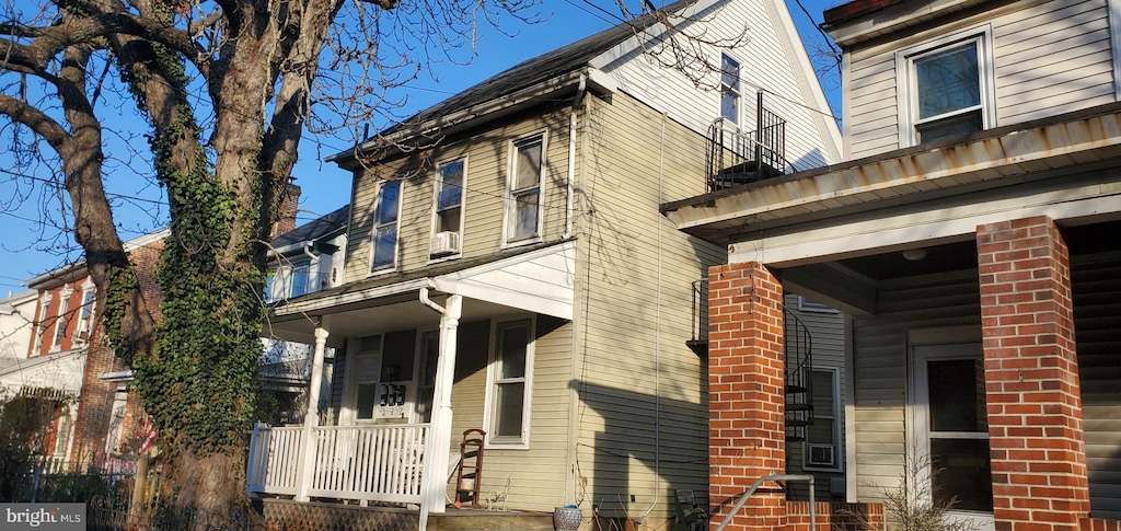 view of side of property featuring covered porch