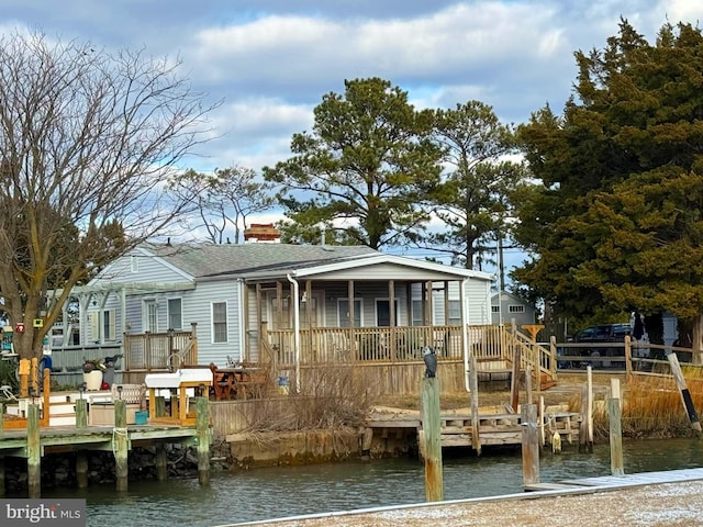 rear view of house with a deck with water view