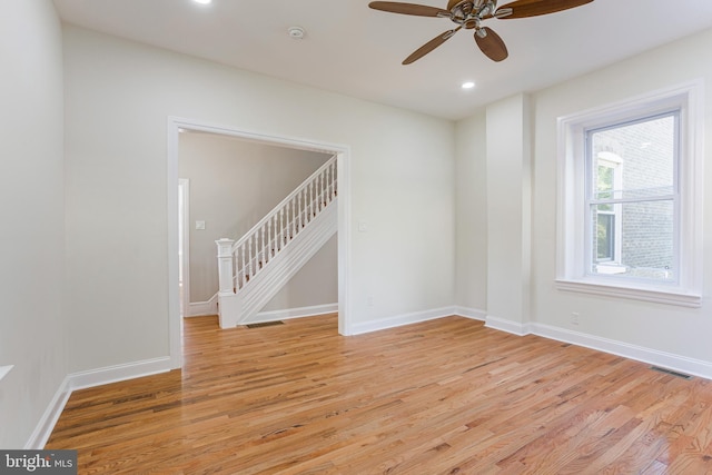 empty room with ceiling fan and light hardwood / wood-style floors