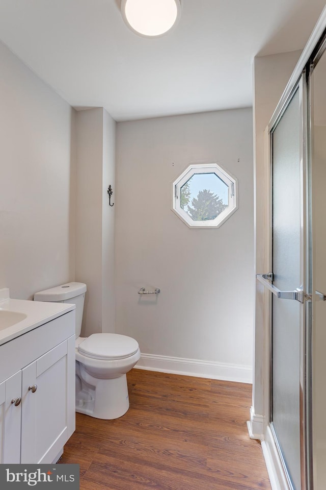 bathroom featuring walk in shower, toilet, vanity, and hardwood / wood-style flooring