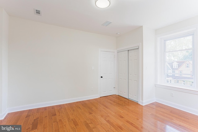 unfurnished bedroom featuring a closet and light wood-type flooring