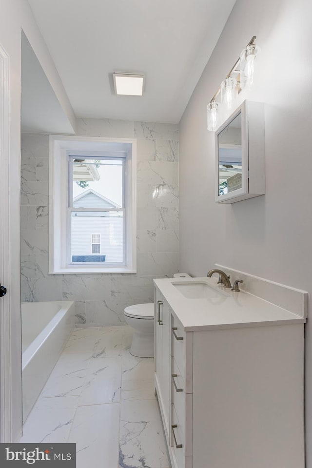 bathroom with a tub to relax in, vanity, and toilet