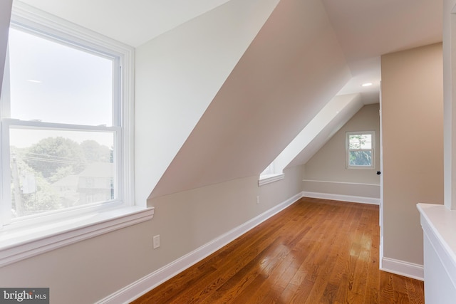 additional living space featuring hardwood / wood-style floors and lofted ceiling