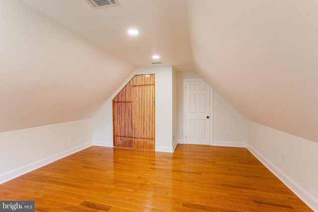 bonus room with hardwood / wood-style flooring and vaulted ceiling