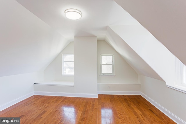 additional living space featuring wood-type flooring and lofted ceiling