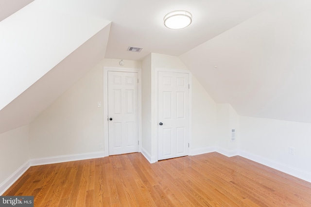 bonus room featuring light wood-type flooring and vaulted ceiling