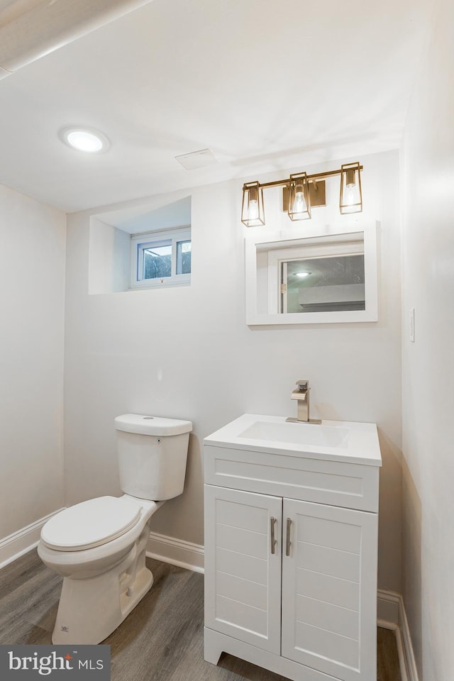 bathroom featuring vanity, wood-type flooring, and toilet