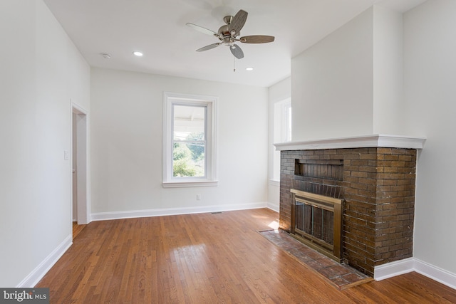 unfurnished living room with a fireplace, hardwood / wood-style flooring, and ceiling fan