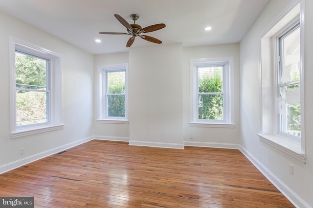 unfurnished room with light hardwood / wood-style flooring, a wealth of natural light, and ceiling fan