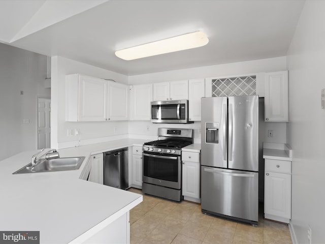 kitchen with sink, stainless steel appliances, kitchen peninsula, and white cabinets