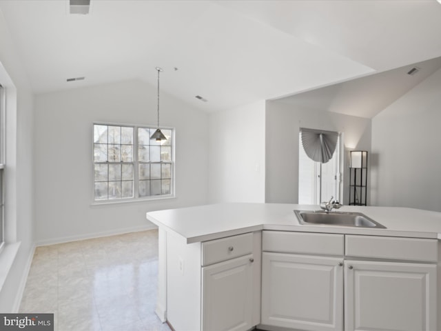 kitchen featuring sink, decorative light fixtures, vaulted ceiling, and white cabinets