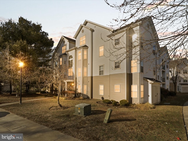 property exterior at dusk with a yard