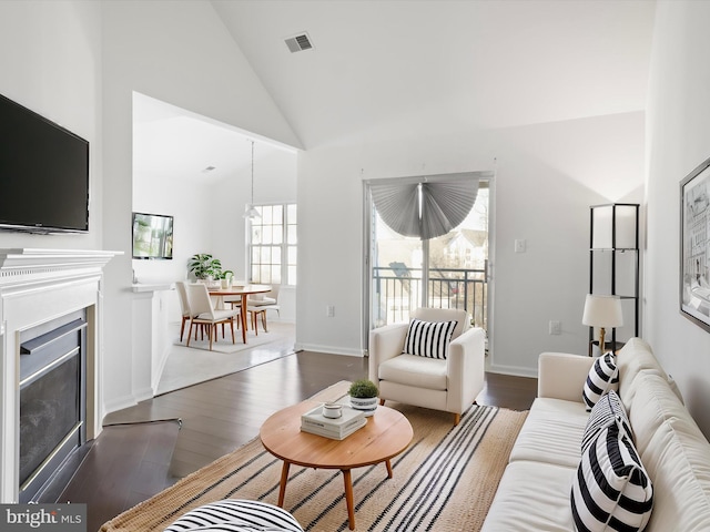 living room with dark wood-type flooring and high vaulted ceiling