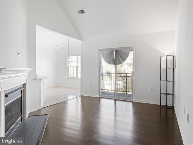 unfurnished living room featuring dark hardwood / wood-style floors and high vaulted ceiling