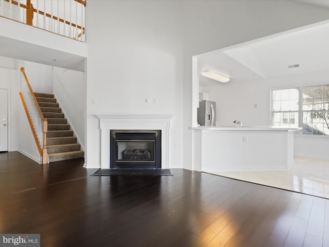 unfurnished living room featuring sink and dark hardwood / wood-style flooring