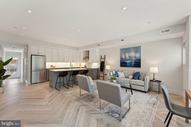 living room featuring sink and light parquet floors