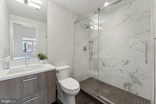 bathroom with tile patterned flooring, vanity, toilet, and a shower with door