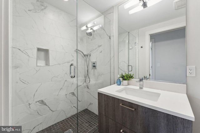 bathroom featuring vanity and a shower with shower door