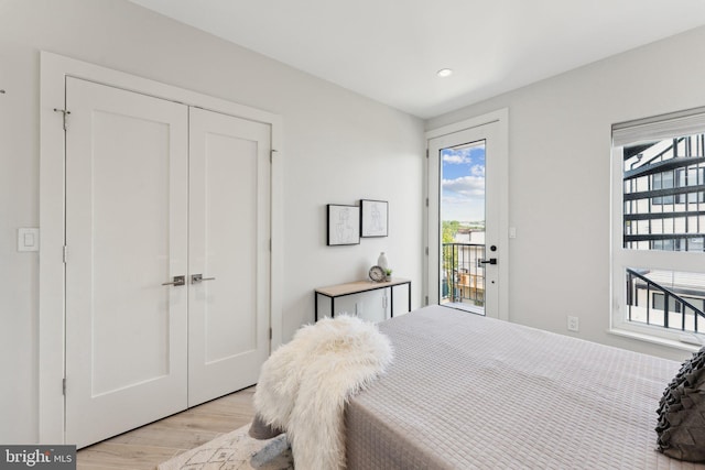 bedroom featuring light hardwood / wood-style floors, access to exterior, and a closet