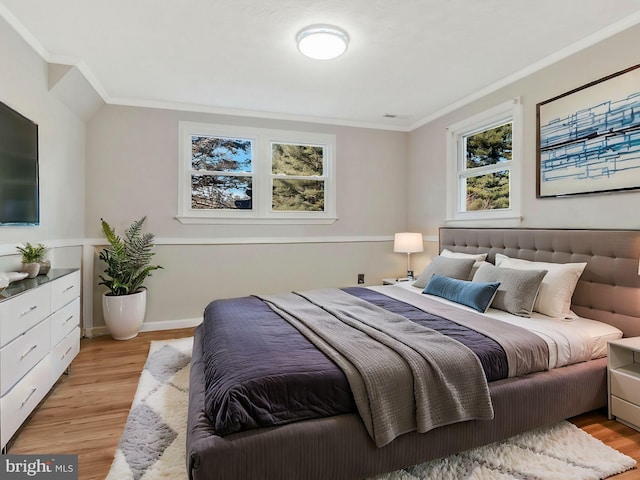 bedroom with light wood-type flooring, multiple windows, and ornamental molding