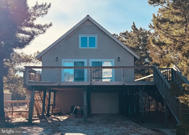 back of house featuring a garage and a deck