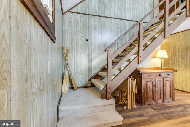 stairway with wood-type flooring and wood walls