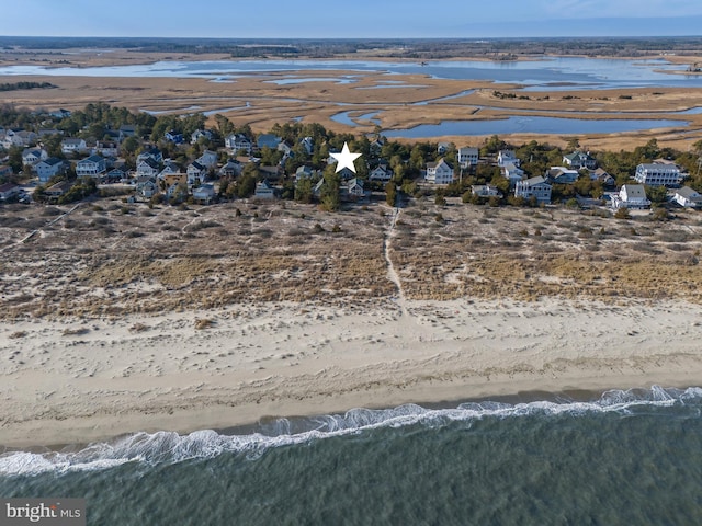 birds eye view of property featuring a water view and a beach view